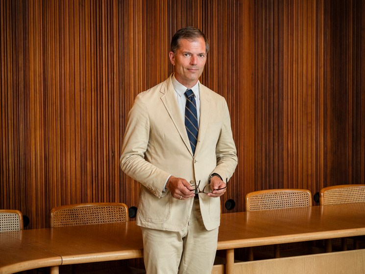 Man in tan suit standing in front of audience