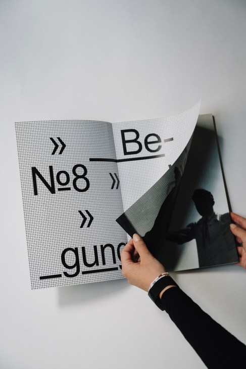 Hand holding open a Bauhaus magazine designed by Herburg Weiland with bold typography and halftone pattern.