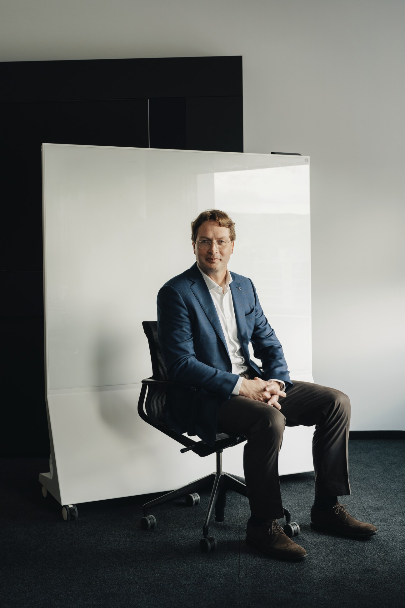 Ola Källenius, chairman of Mercedes-Benz, sitting in a modern office environment during the interview