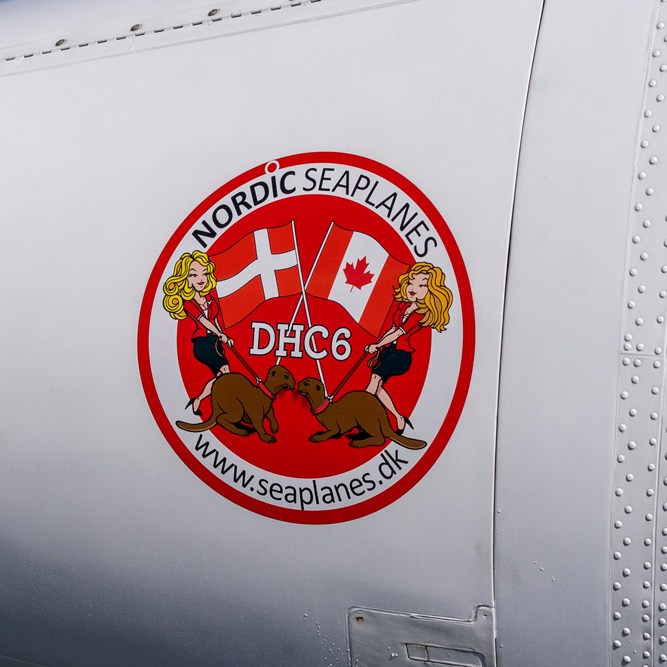 Nordic Seaplanes DHC6 Twin Otter aircraft fuselage with red circular logo featuring Swiss and Canadian flags.