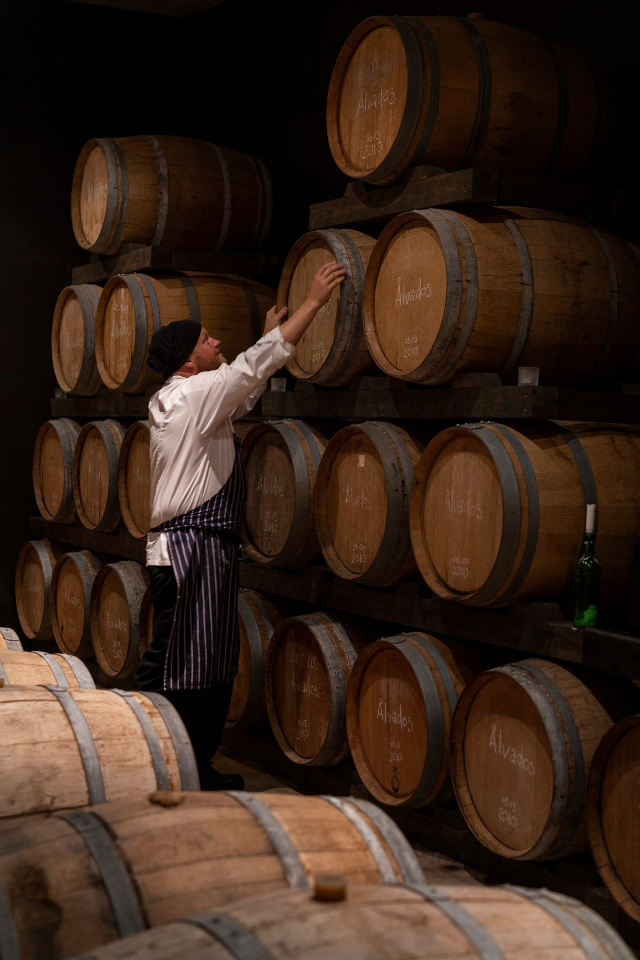 Chef Michael Björklund working with wooden barrels in cellar storage area
