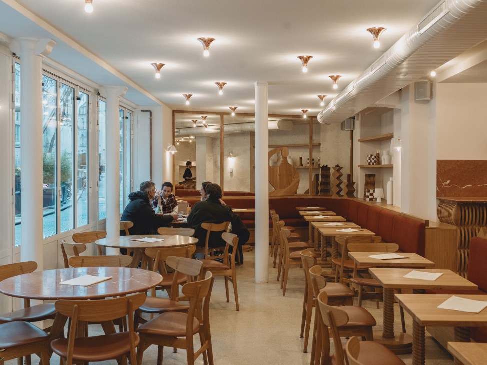 Modern restaurant interior with wooden tables, chairs, and warm lighting in Café Compagnon