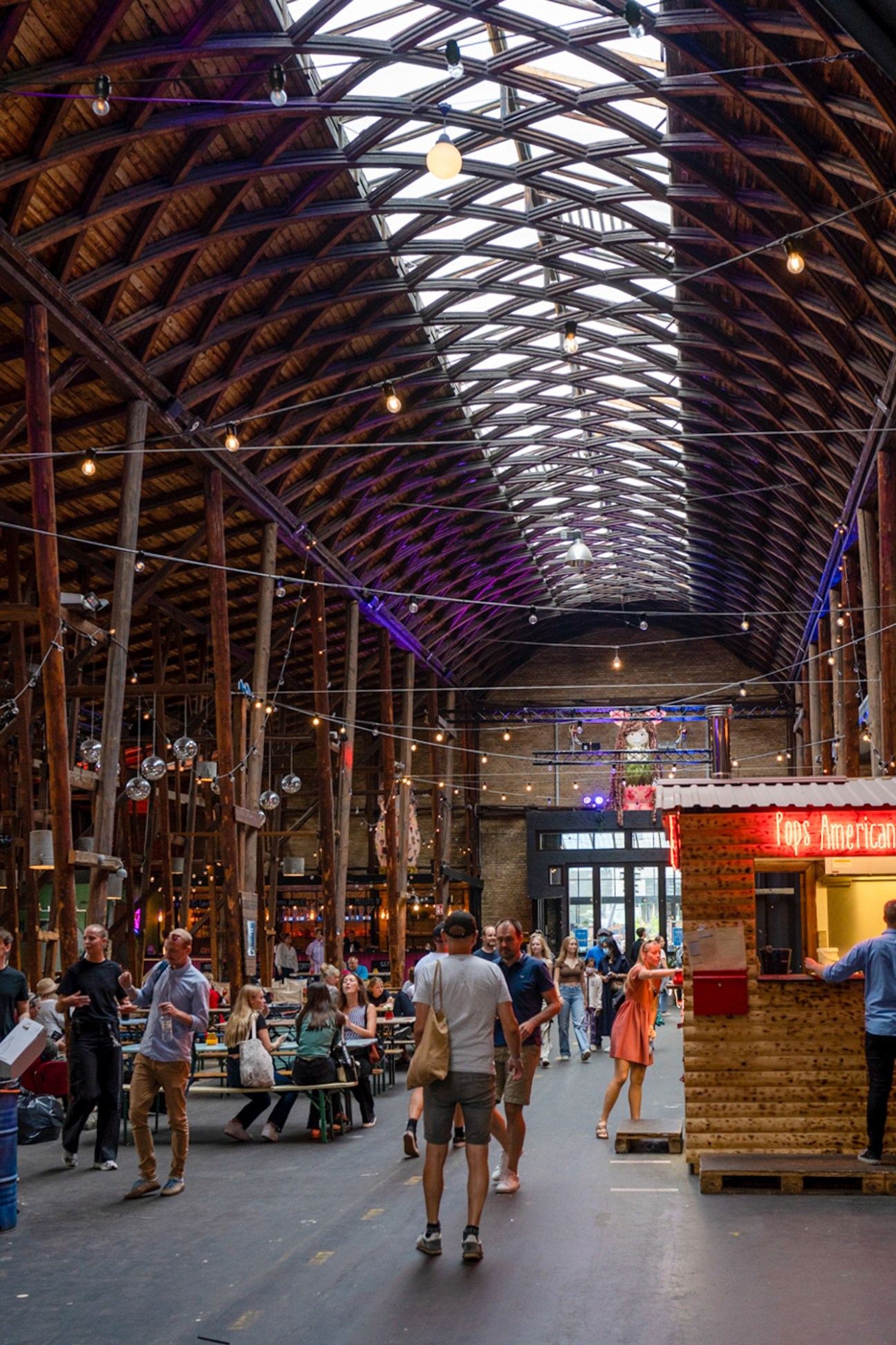 Interior view of Storms Pakhus food market showing various food stalls and dining areas in converted warehouse space