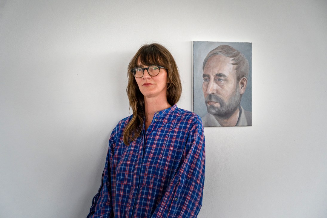 Henrikke Nielsen from Croy Nielsen gallery standing in front of a white wall with a portrait painting
