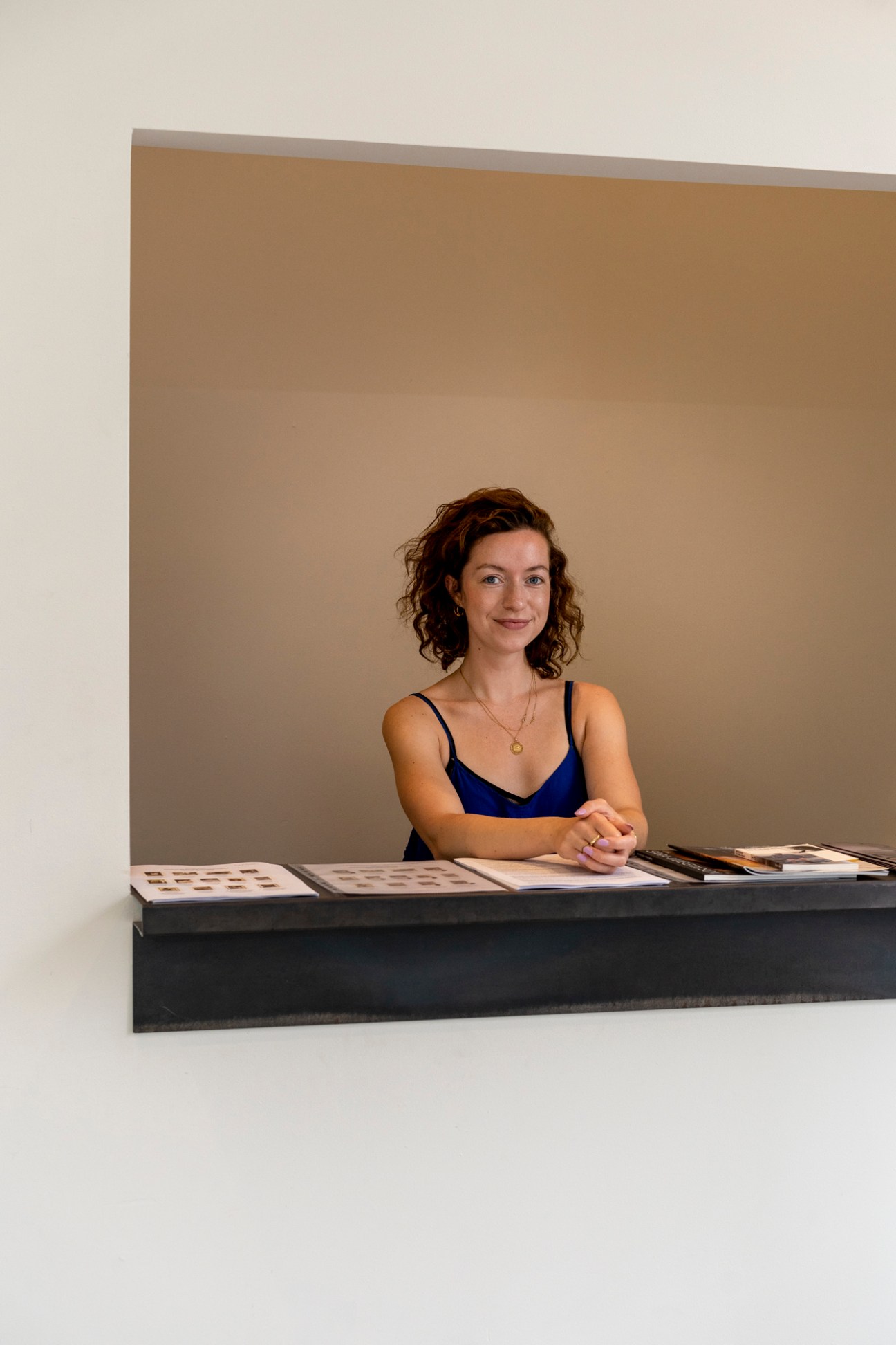 Amanda Faerk, assistant director of V1 Gallery and Eighteen, sitting at a desk in a gallery space