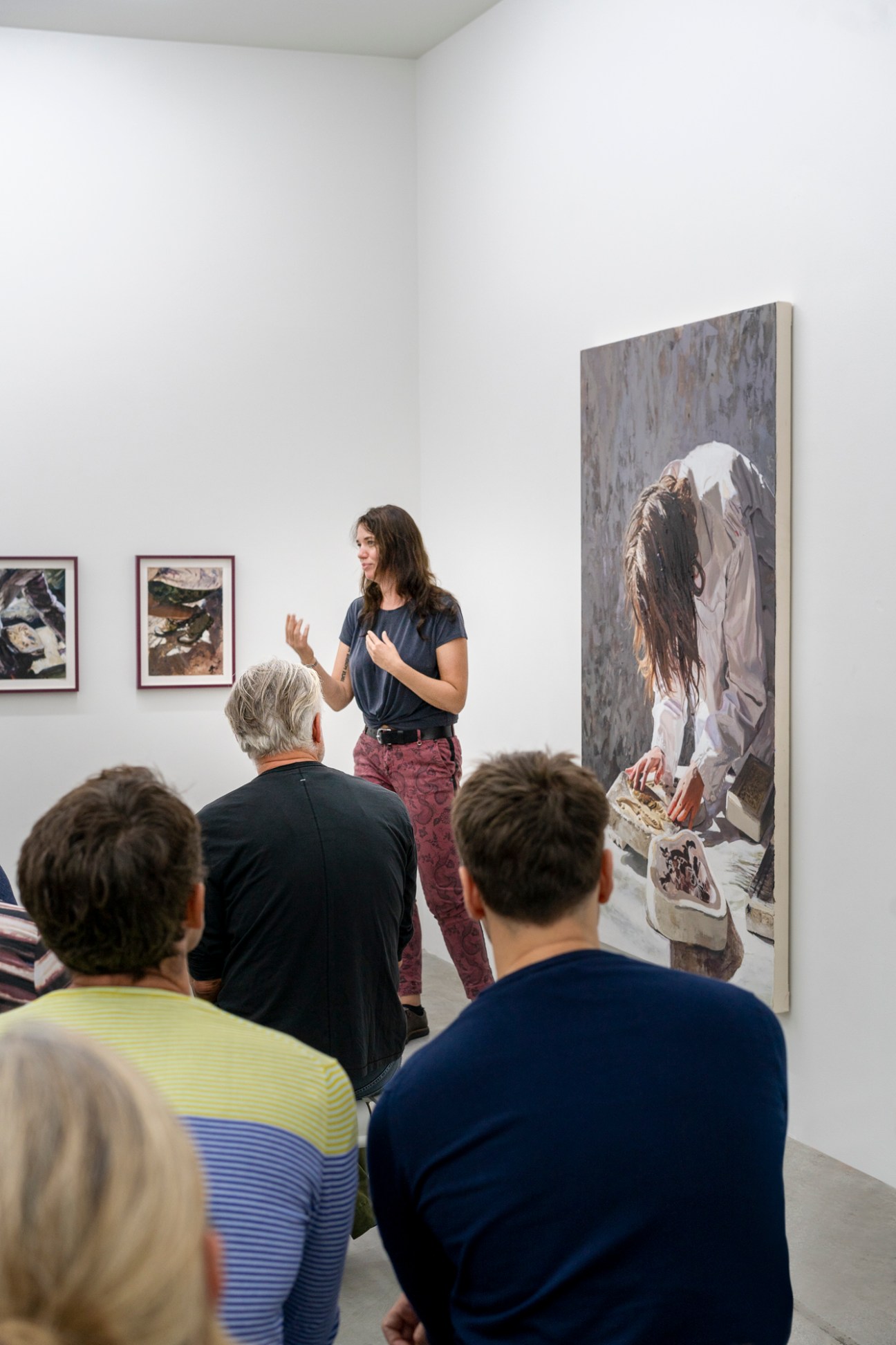 Sara-Vide Ericson giving a presentation to seated audience members in a white-walled gallery space