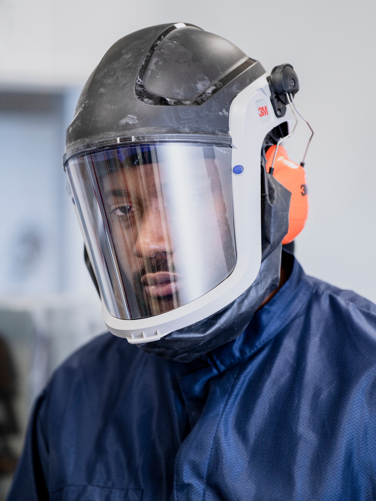 Portrait of artist Matthew Angelo Harrison wearing protective face shield and blue protective clothing
