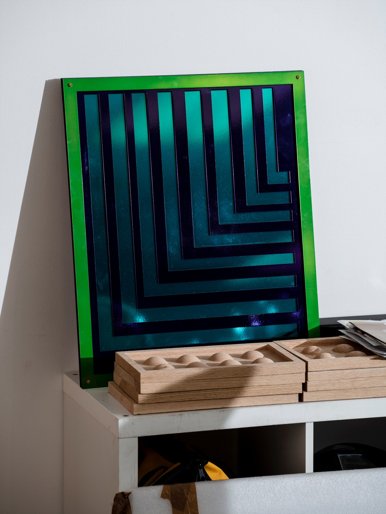 Contemporary artwork with green frame and blue geometric pattern in Tiff Massey's studio