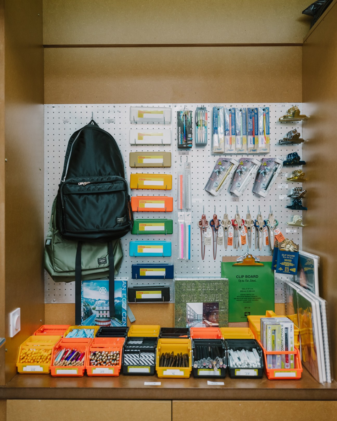 Well-organized pegboard display with stationery supplies, pens, scissors, clipboards and storage containers