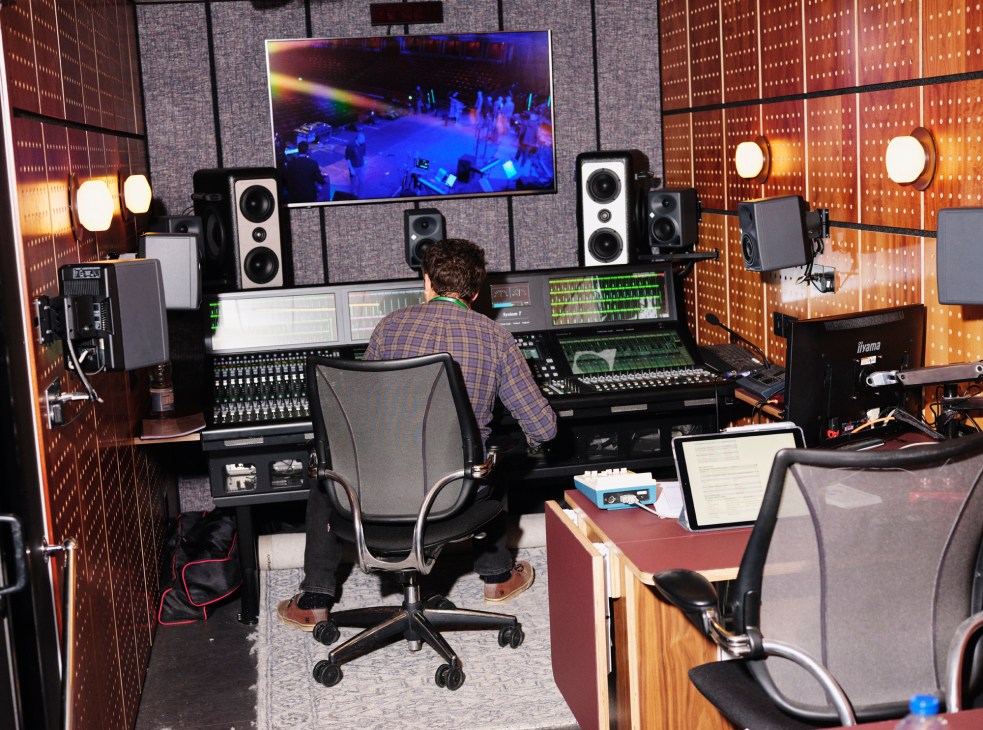 Comfortable seating area inside broadcast truck with upholstered chairs and tables