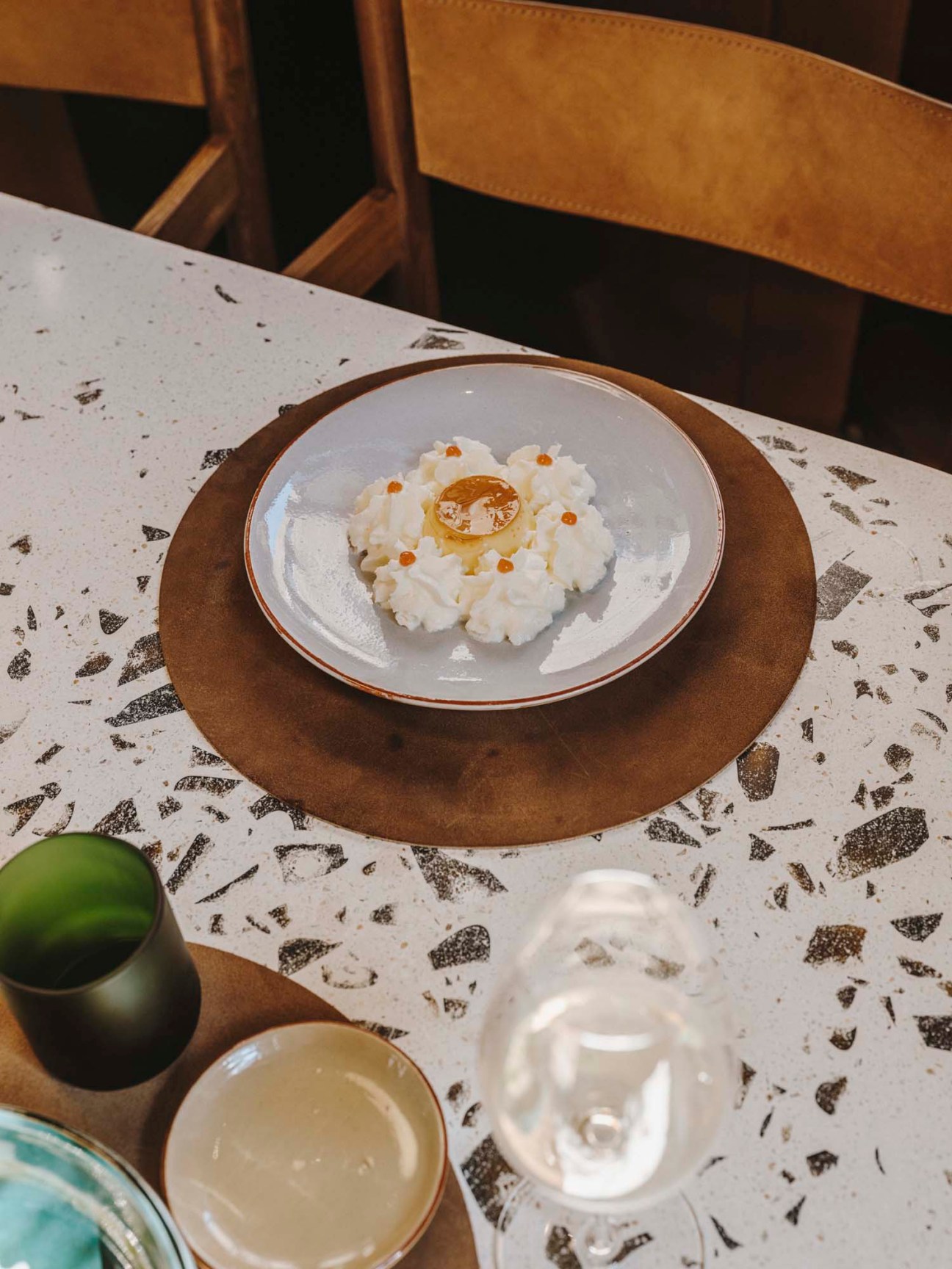 Sheep's milk flan dessert plated elegantly on white ceramic dish