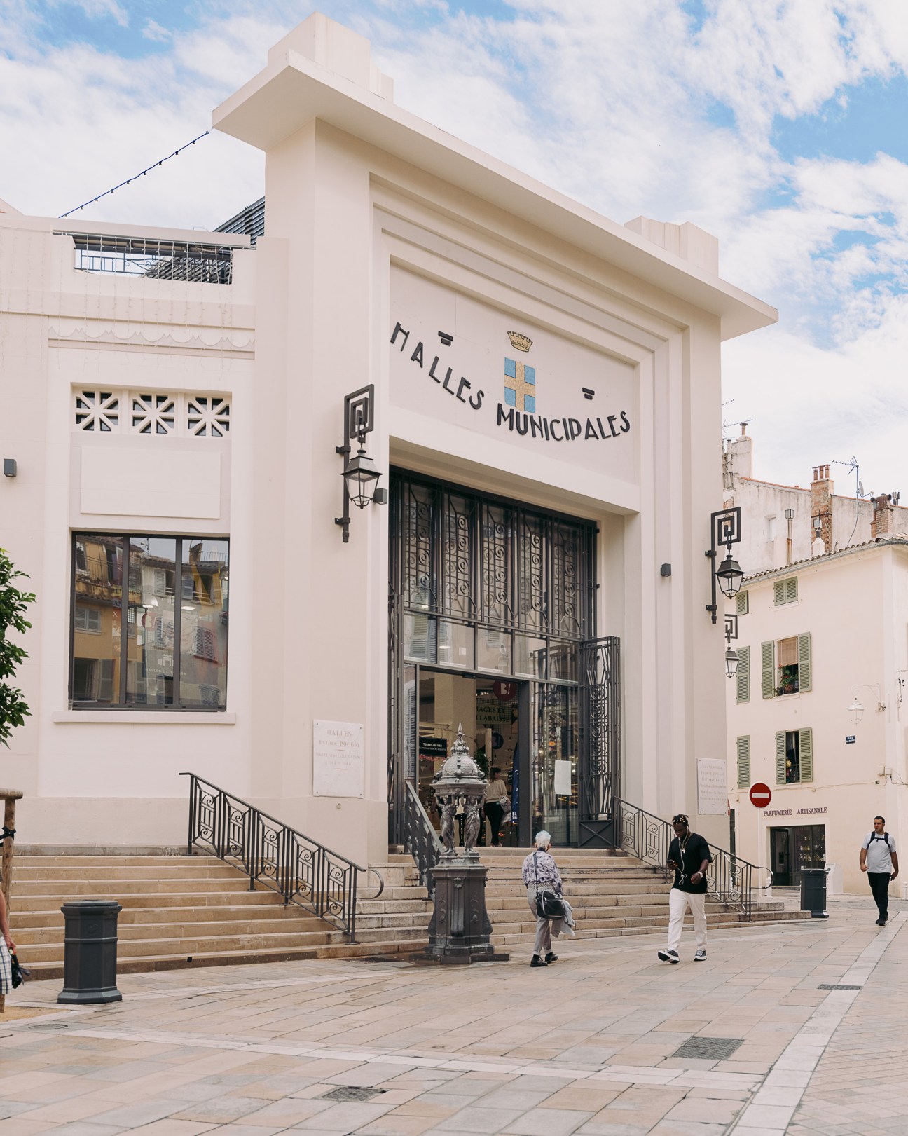 Halles Municipales building facade in Girona with cream-colored modernist architecture and ornate ironwork doors.