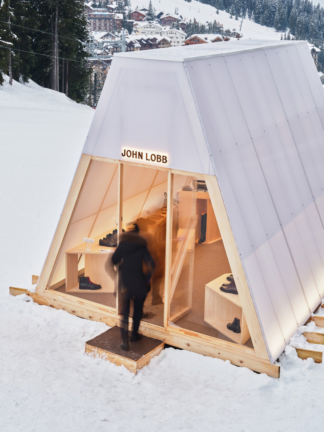 Interior detail of John Lobb Alpine installation showcasing luxury shoe displays within minimalist white pavilion design
