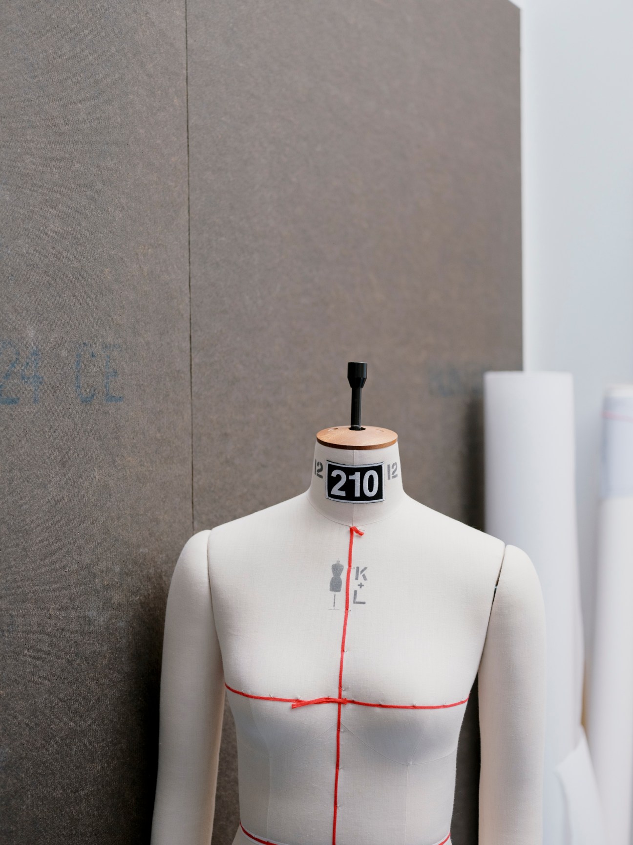 White dress form mannequin with measurement markings and red guidelines in 66°North showroom.