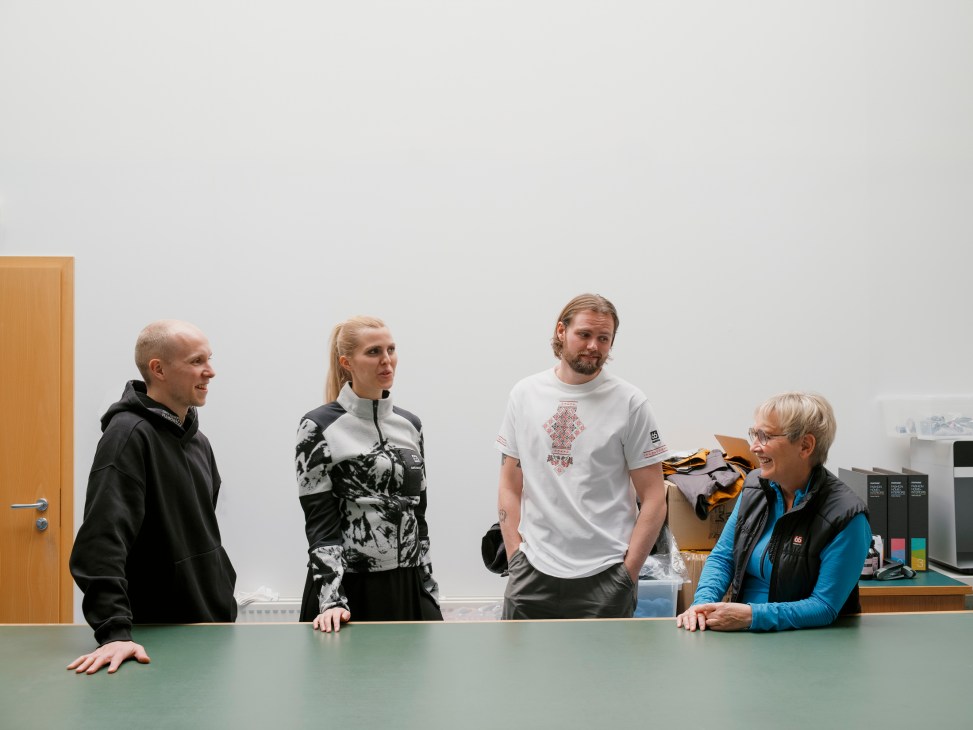 Four 66°North employees gathered around a table during a meeting in an office space.