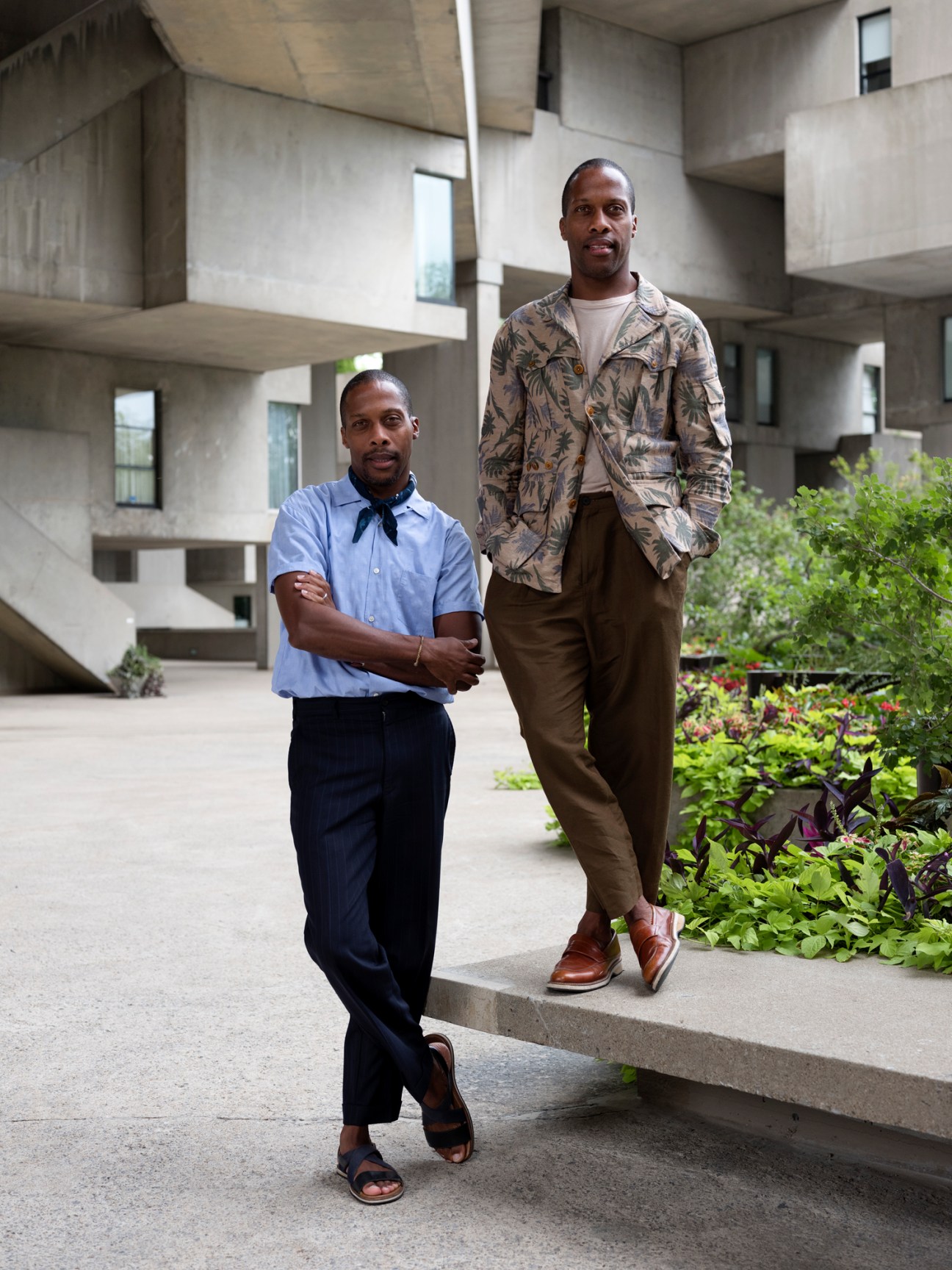 Byron and Dexter Peart standing in a modern concrete courtyard with landscaping.