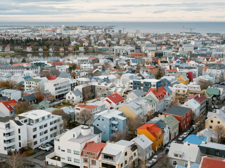 Aerial view of Reykjavik's colourful rooftops stretching to the sea.