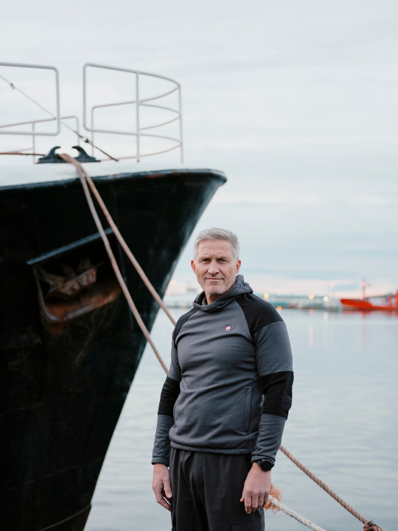 Helgi Oskarsson, CEO of 66°North, standing by a fishing boat in Reykjavík harbor wearing 66°North outerwear.