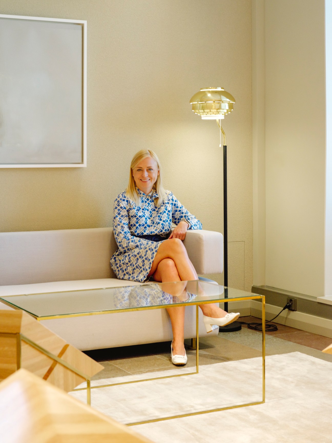 Elina Valtonen, Finland's foreign minister, sitting on a cream sofa in a minimalist office with a geometric brass table.