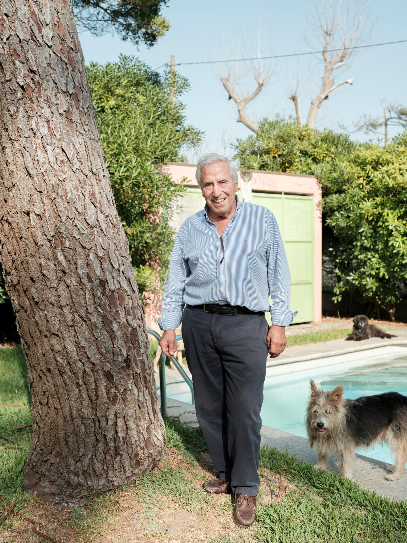 João Pinto de Sousa stands in a garden with a pool and small dog nearby