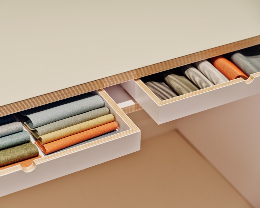 Organized drawer compartments containing neatly folded textile samples and fabric swatches in various colors