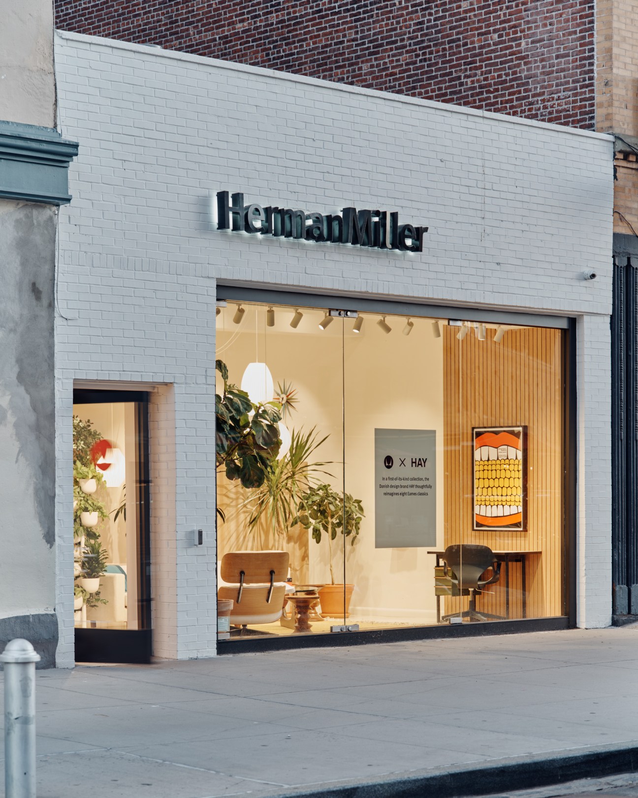 Herman Miller storefront with white brick facade and large windows displaying modern furniture and plants