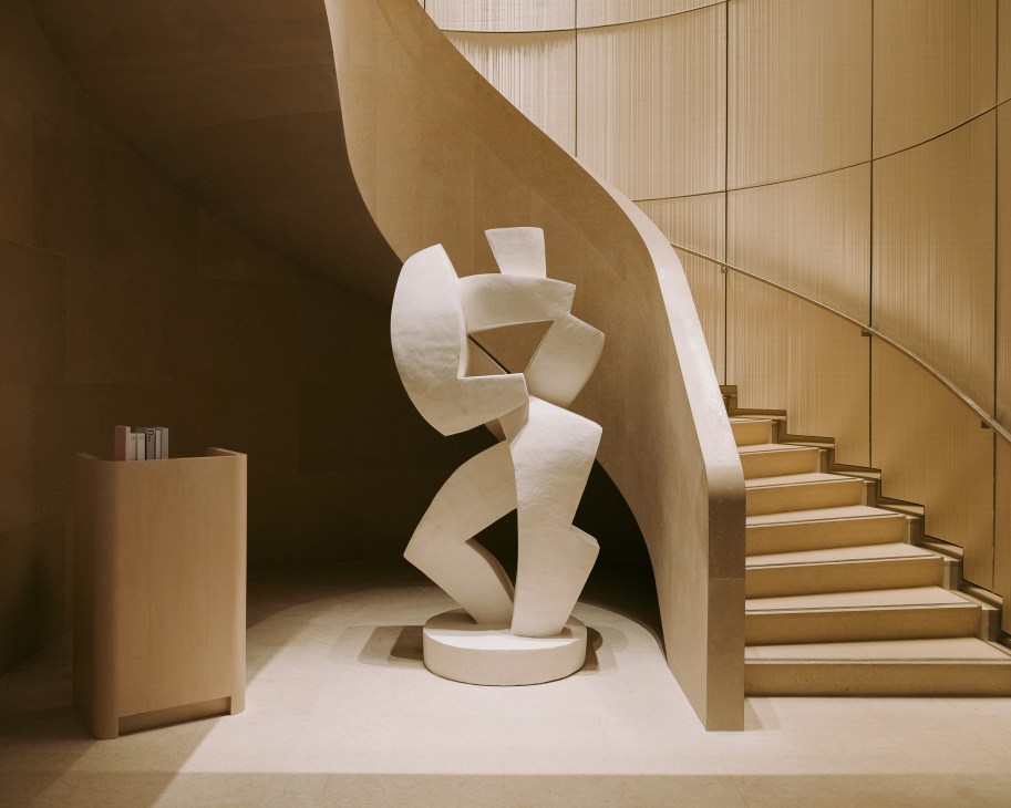 White abstract sculpture by Florian Tomballe in Le Cheval Blanc hotel foyer with wooden stairs and neutral tones.