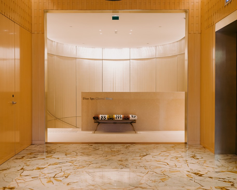 Dior spa reception at Le Cheval Blanc with warm wood paneling and marble flooring.