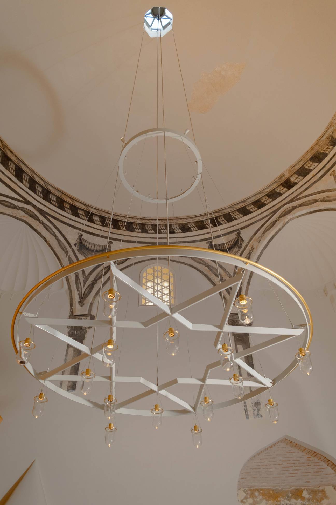 an ornate chandelier hanging from a high, domed ceiling