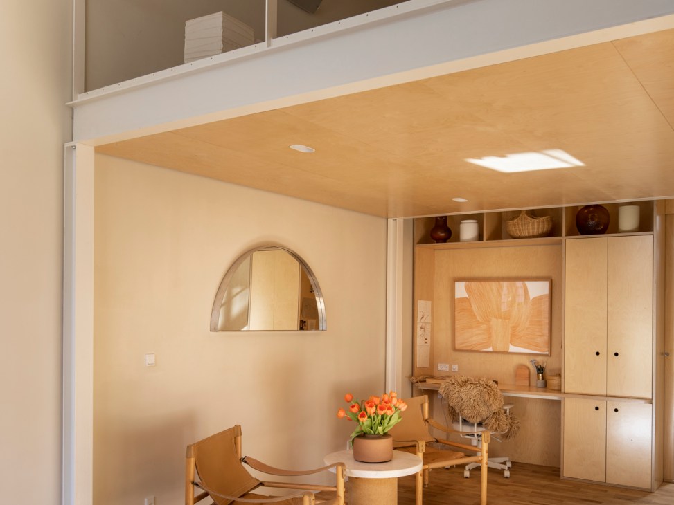 Minimalist interior with wooden furniture, potted flowers, arched mirror and built-in storage cabinetry in warm neutral tones.