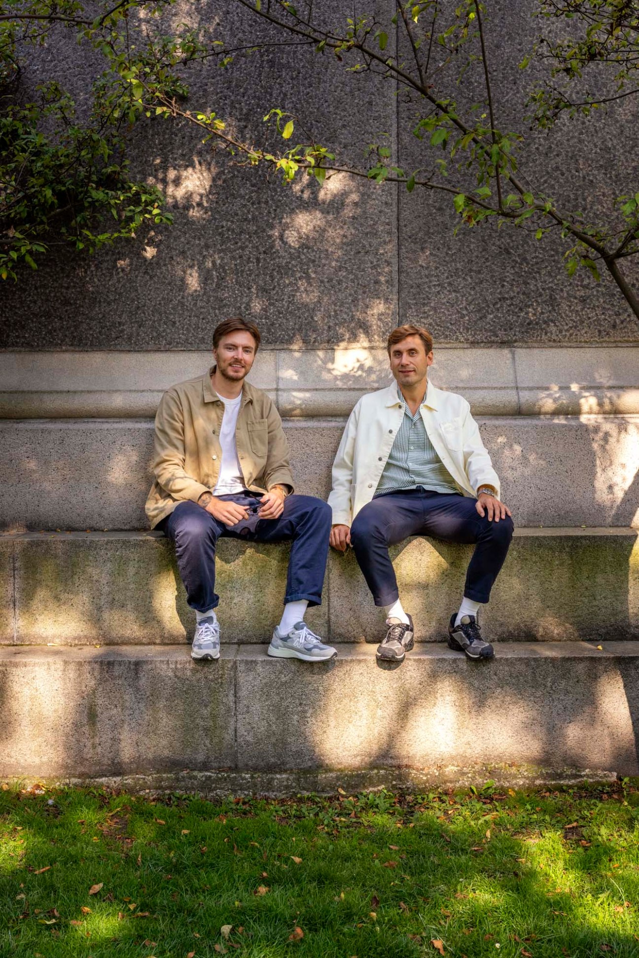 Jesper Finderup and Jeppe Alexander Meier, founders of Forét Studio, sitting on a concrete ledge in Copenhagen