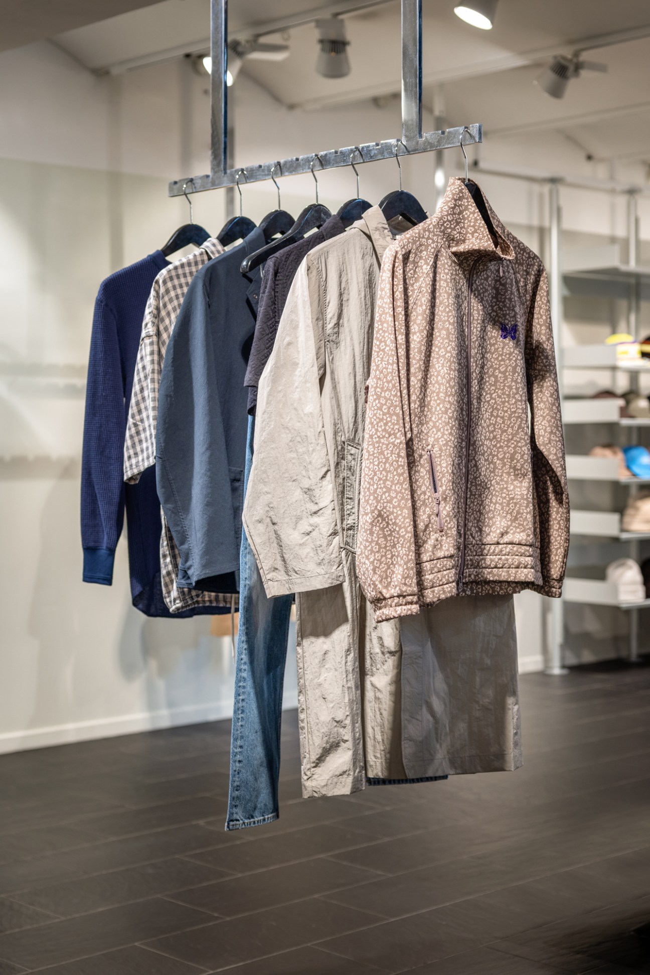 Interior view of Stoy menswear store showing clothing racks with garments hanging on display