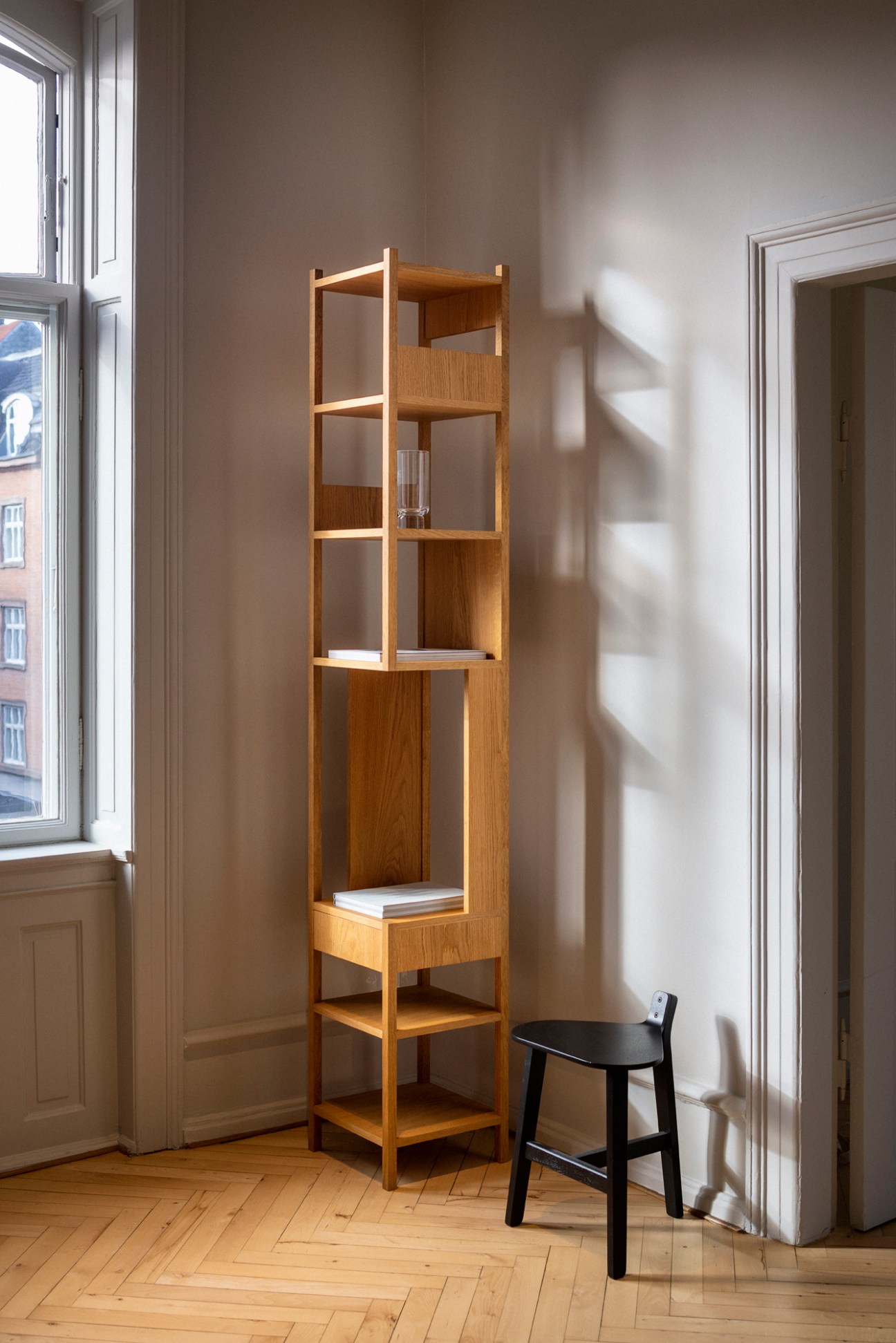 Tall wooden modular shelving unit with multiple compartments and geometric design