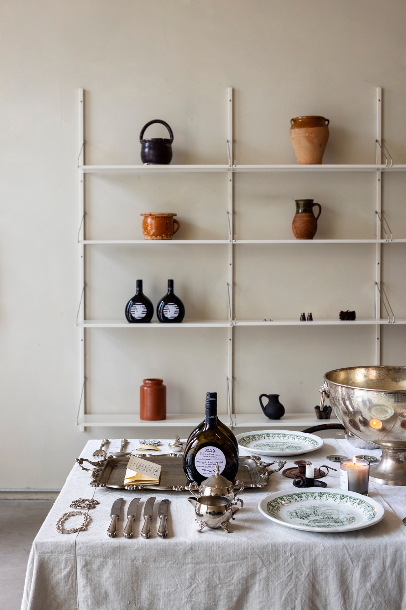 Vintage wares from Berlin displayed on white shelving in minimal gallery space