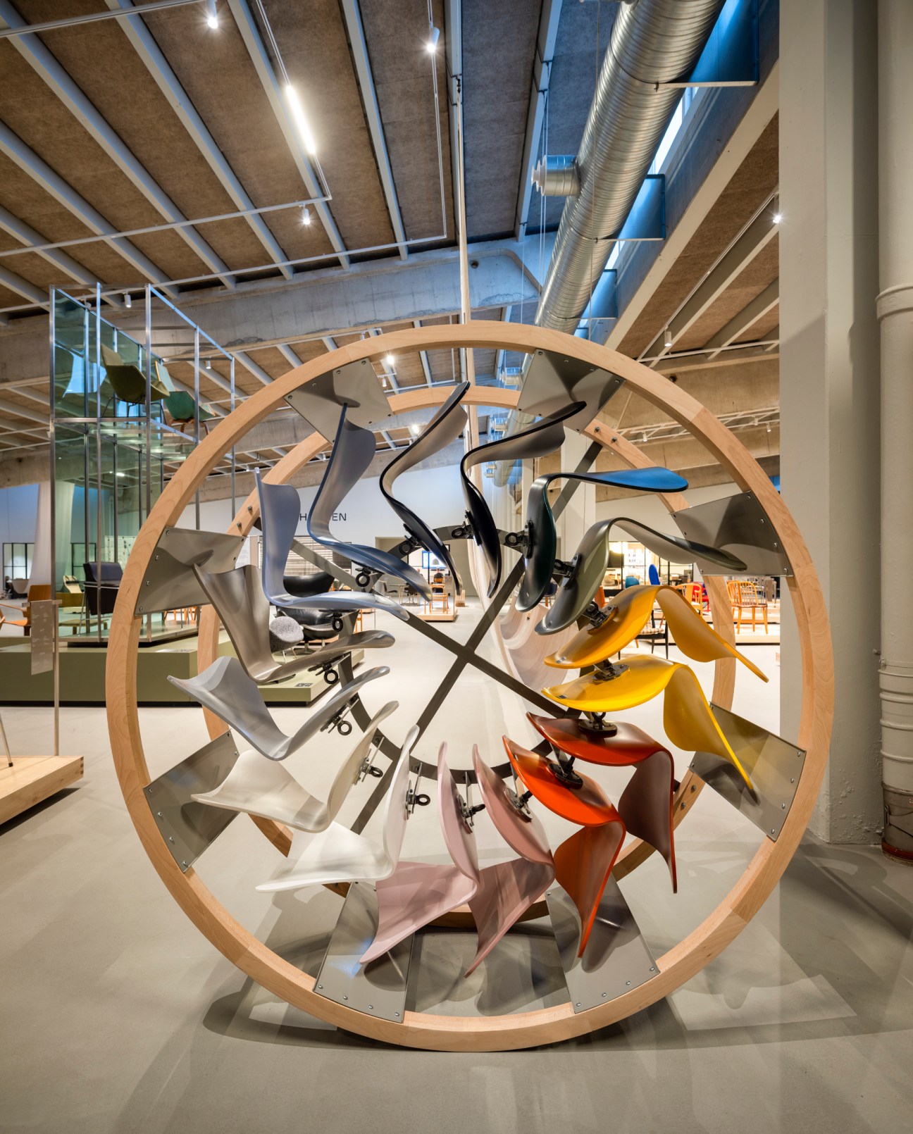 Colorful Series 7 chairs arranged in a circular wooden display wheel at Fritz Hansen's Design Hall