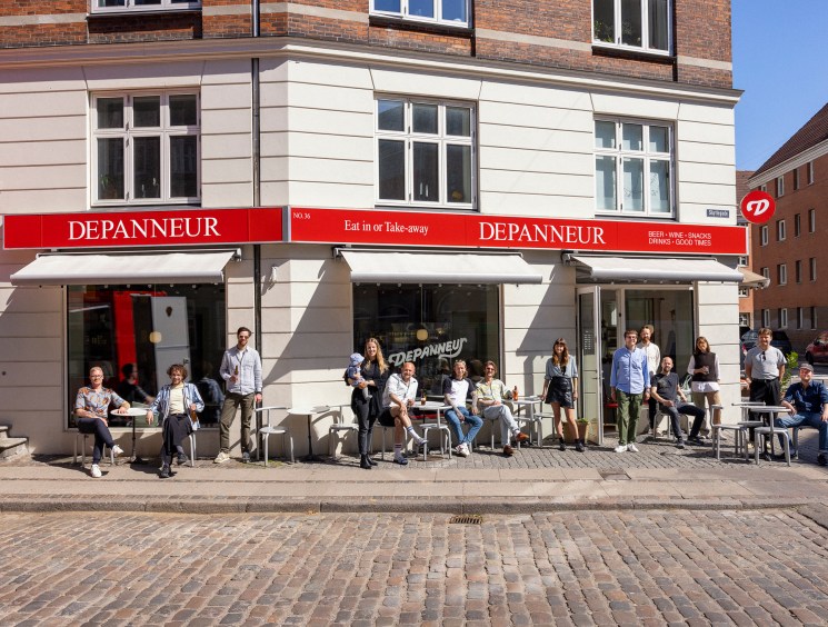 The Depanneur team posing outside their Copenhagen bar and shop storefront on a cobblestone street
