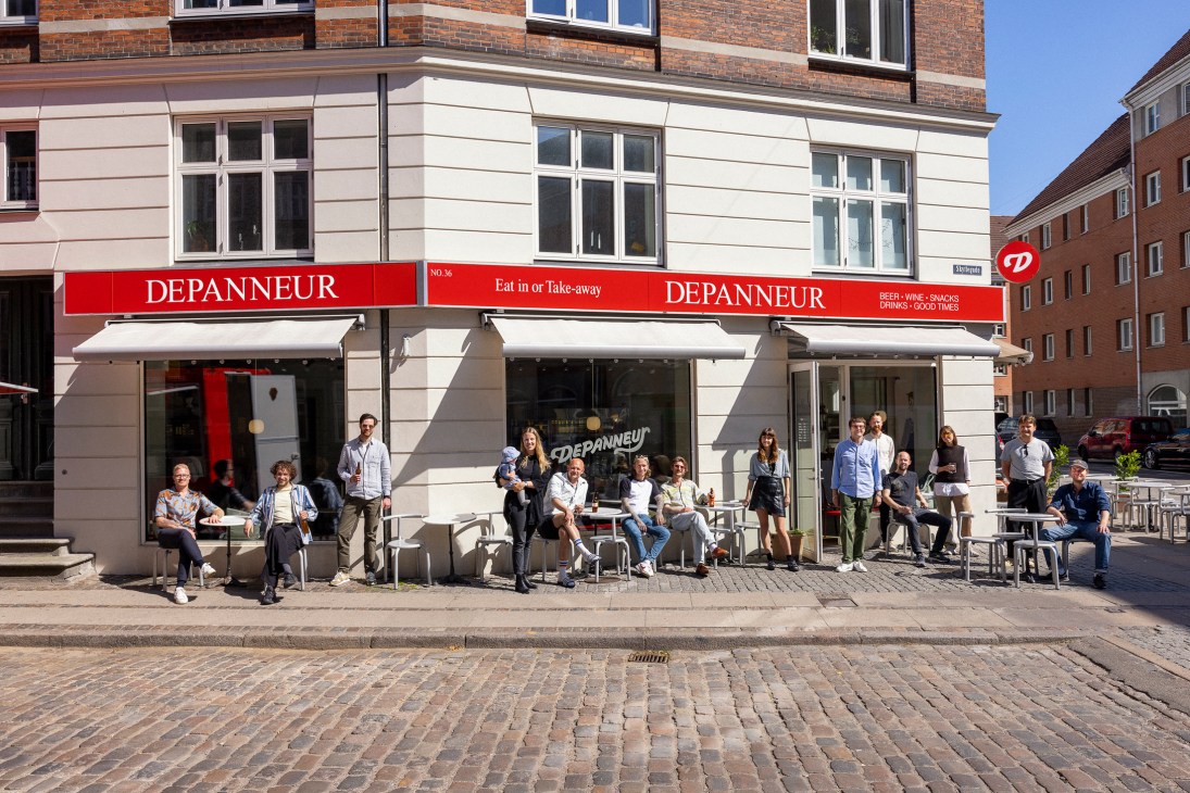 The Depanneur team posing outside their Copenhagen bar and shop storefront on a cobblestone street