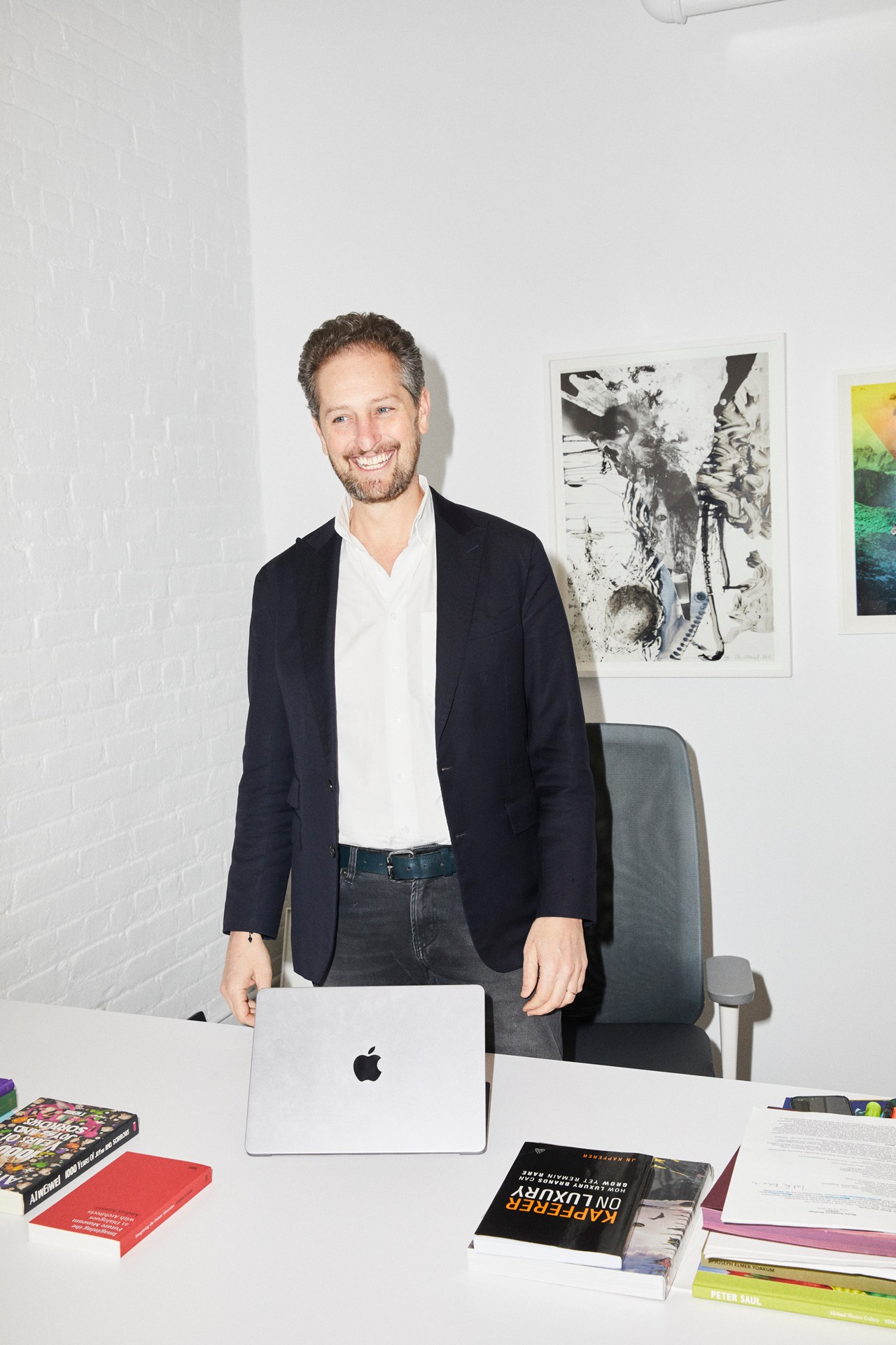 Noah Horowitz, CEO, standing behind desk with laptop and books in modern office