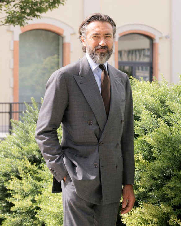 Manfredi Catella, CEO of Milan-based developer Coima, stands outdoors in a grey suit against a building with arched windows.