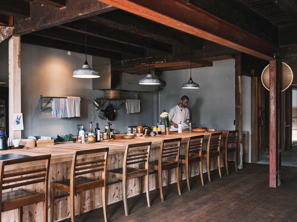 Interior of Beard restaurant showing wooden counter with eight chairs and exposed ceiling beams