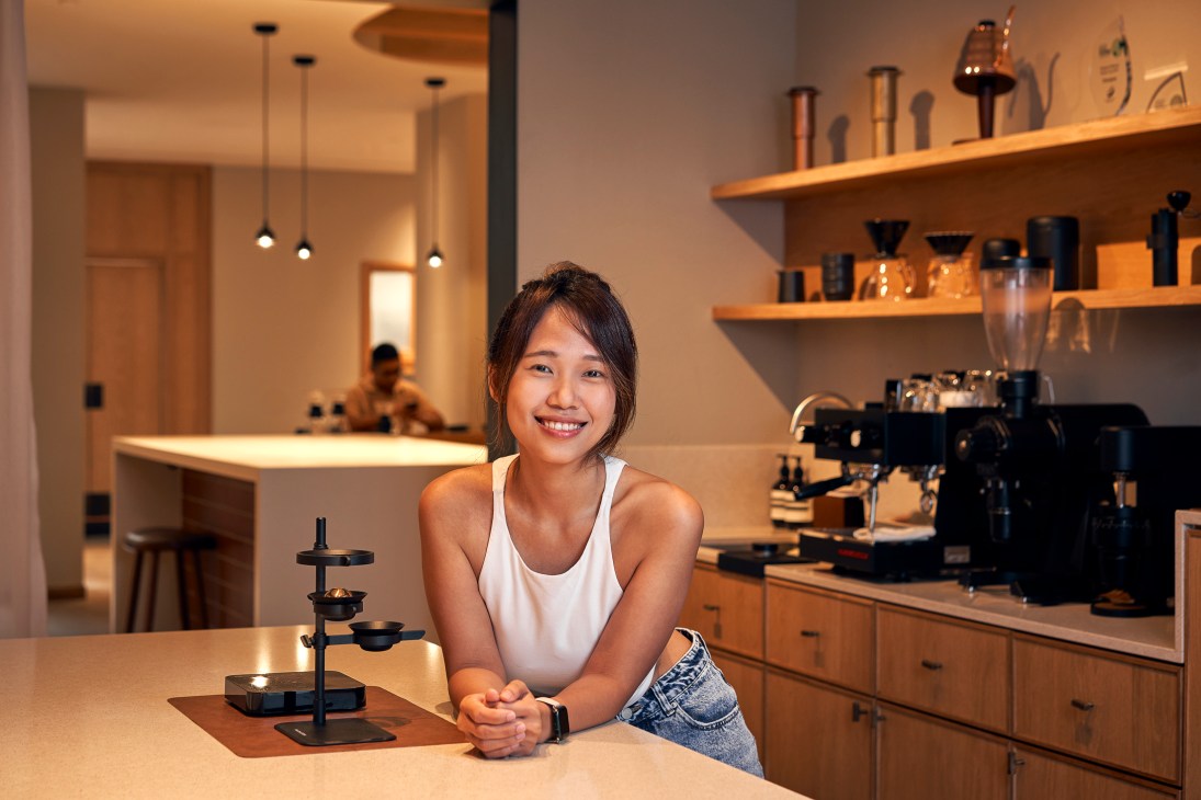 Elysia Tan, co-founder of Homeground Coffee Roasters, smiling behind the counter at her Singapore café
