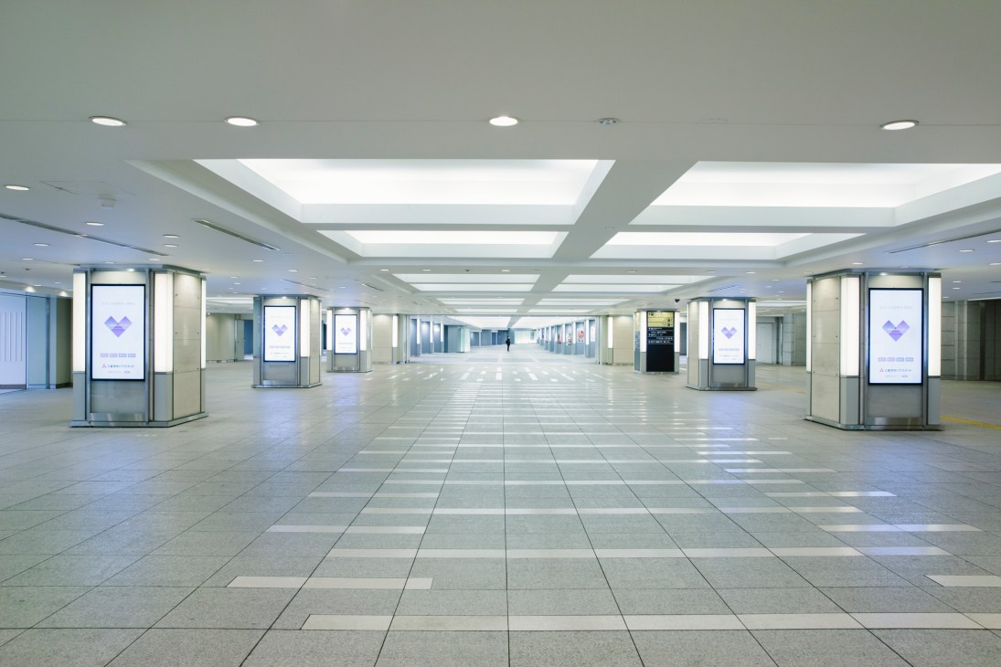 Empty underground corridor with skylights in Tokyo station during pandemic lockdown.