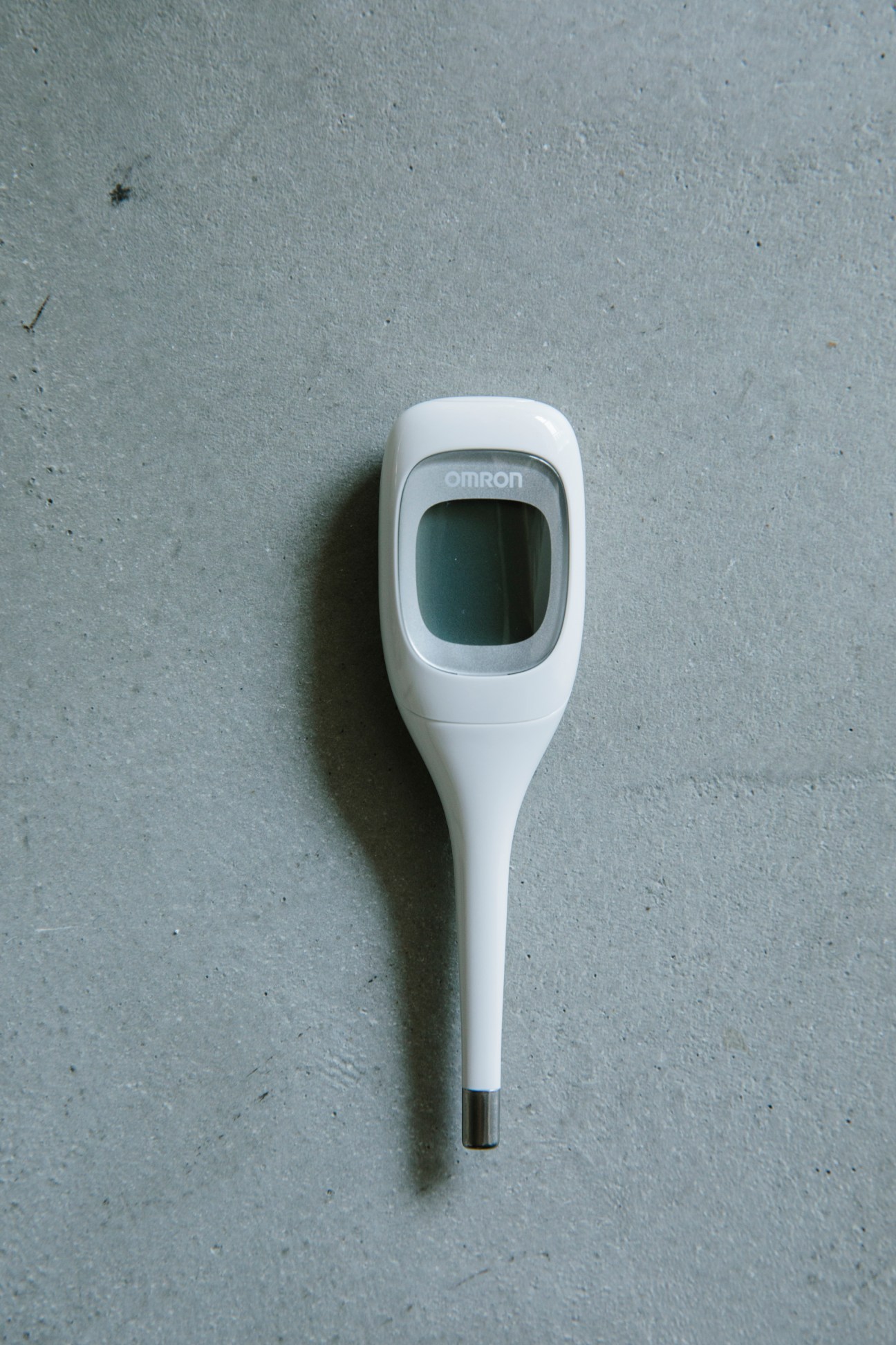 White Omron digital thermometer with LCD display and ergonomic handle design