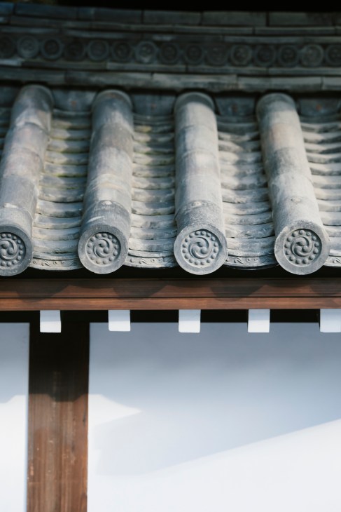 Traditional Japanese roof tiles with decorative circular patterns and spiral motifs arranged in rows