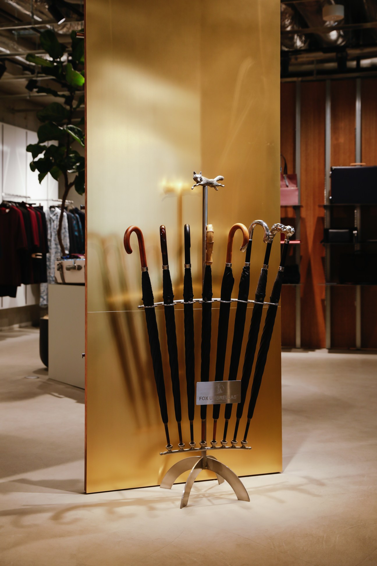 Golden reflective umbrella stand display in retail interior