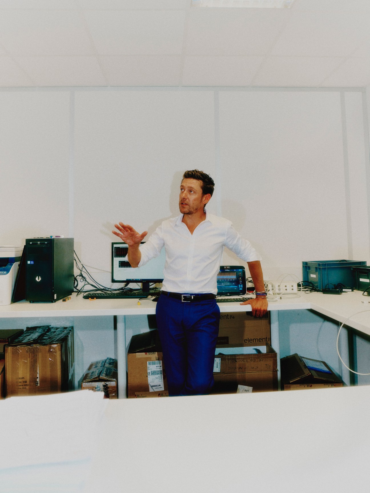 Fabien Pagniez standing in office space with computer equipment and storage boxes visible in background