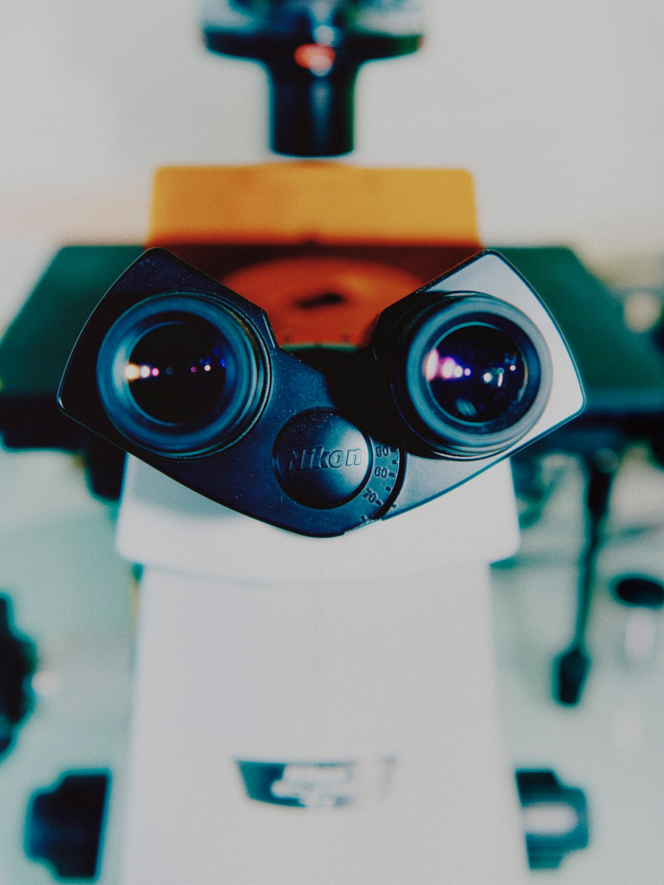 Close-up view of Nikon microscope eyepieces with blue-tinted lenses in a medical research laboratory setting