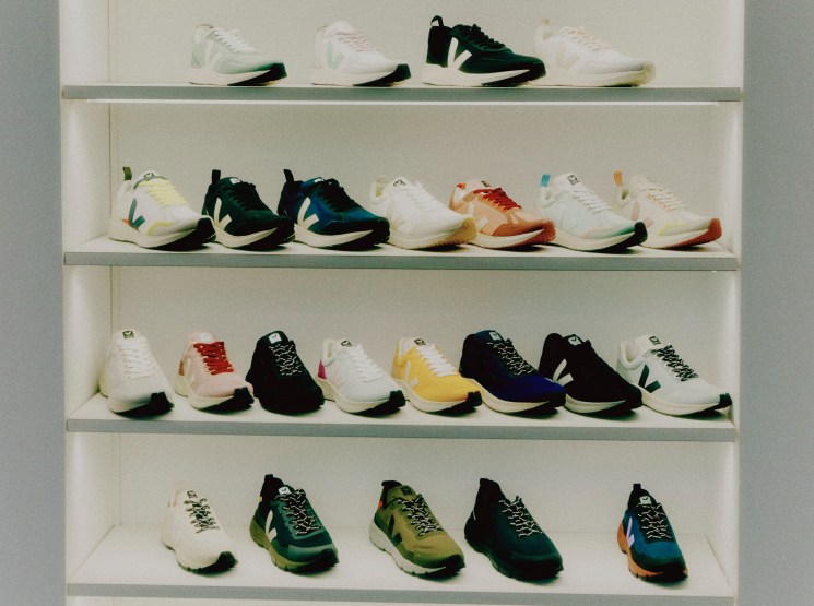 Display of colorful Veja sneakers arranged on white shelves in retail setting