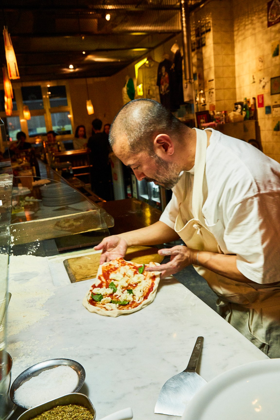 Chef Daisuke Nakamura preparing a margherita pizza at Bacar restaurant in Naha, Okinawa.