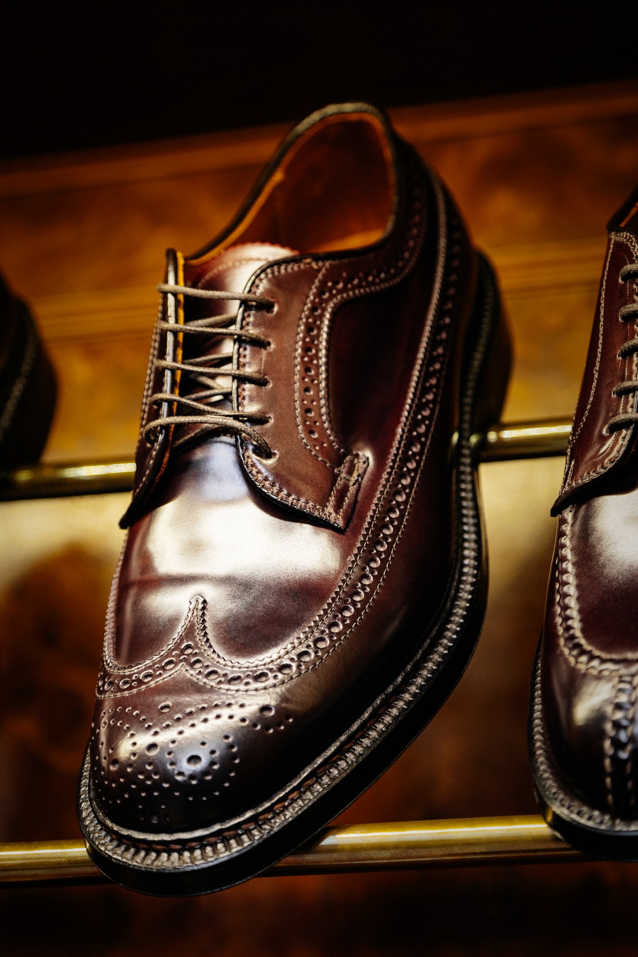 Close-up of brown leather brogue dress shoes with decorative perforations and lace-up closure